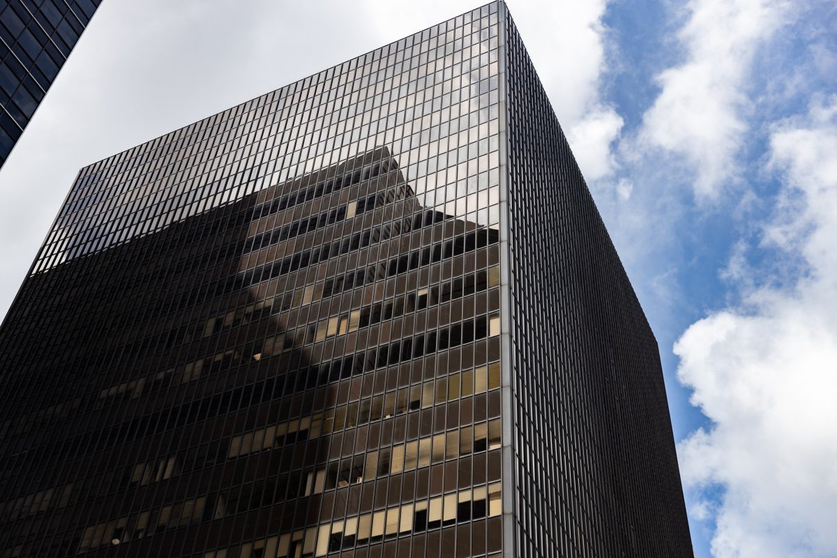 Modern office building featuring dark commercial window tinting against a blue sky